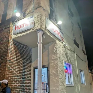 two people standing outside of a restaurant