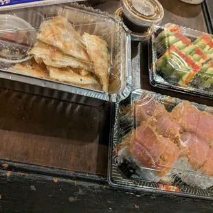 a variety of sushi in plastic containers