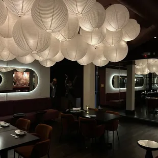 a dining room with a lot of paper lanterns hanging from the ceiling