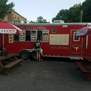 a woman standing in front of a food truck