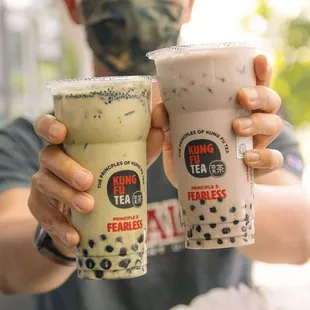 a man holding two drinks