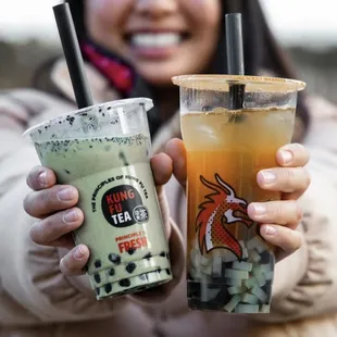 a woman holding two drinks