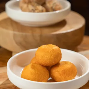 a bowl of fried doughnuts on a cutting board