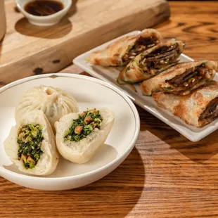 a plate of dumplings and a bowl of dipping sauce