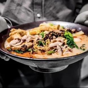 a person holding a bowl of soup