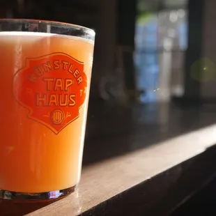 a glass of beer on a bar