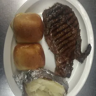 steak, potatoes, and bread on a plate