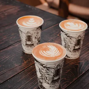 three cups of coffee on a wooden table