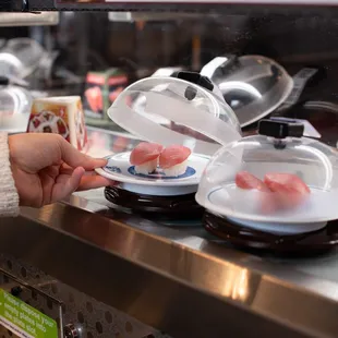 a person placing sushi in a bowl