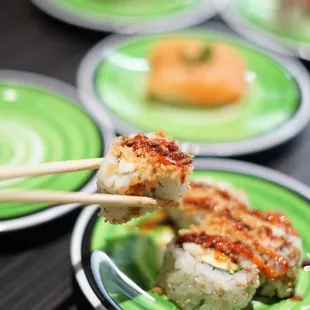 a plate of sushi with chopsticks