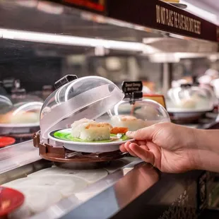 a person reaching for sushi