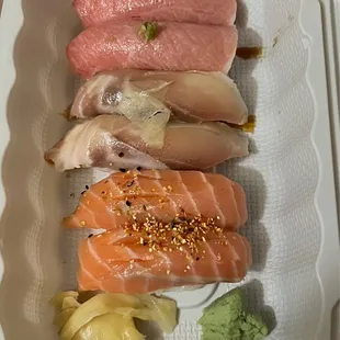 a variety of sushi in a styrofoam container