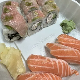 a variety of sushi on a styrofoam tray