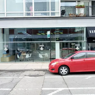 a red car parked in front of a building