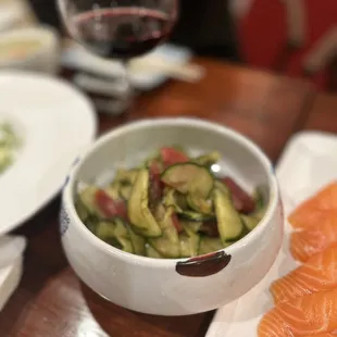 a bowl of salmon and a bowl of cucumbers