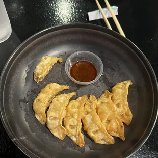 a plate of dumplings with dipping sauce