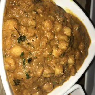 a bowl of curry with a spoon in it