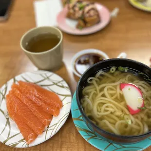 a bowl of ramen and a plate of salmon