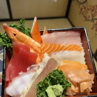 a person holding a plate of sushi