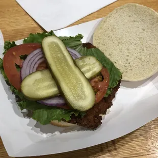 a sandwich with pickles and tomatoes