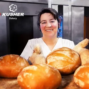 a woman holding a tray of freshly baked bread