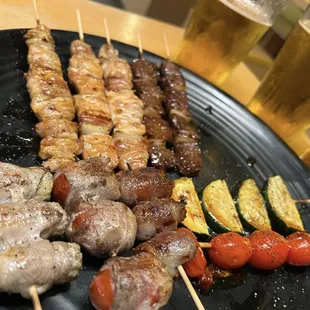 10 skewer combo. 3 chicken thighs, two ribeye, tomato, corn, and fig wrapped in bacon, and a tomato and zucchini skewer.