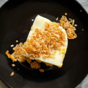 a dessert on a black plate