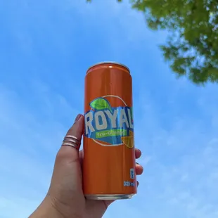 a hand holding a can of soda