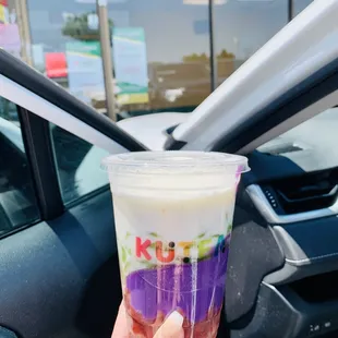 a hand holding a cup of milk tea