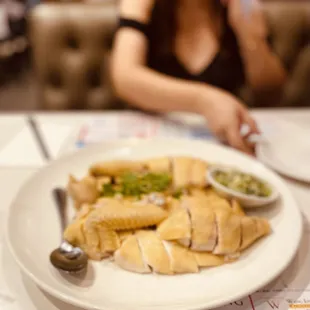 a plate of food with a woman in the background
