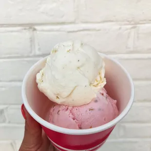 a hand holding a cup of ice cream