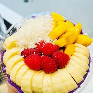 a hand holding a bowl of fruit