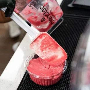 a person pouring liquid into a cup