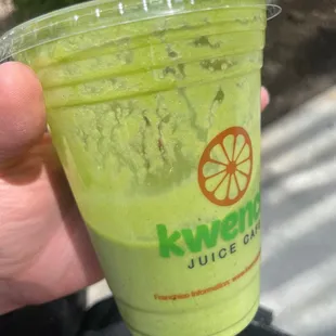 a hand holding a green drink