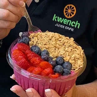a woman eating a bowl of fruit