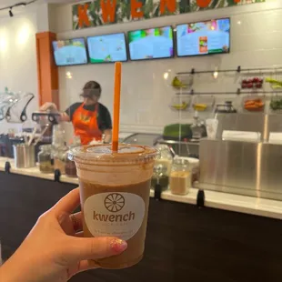 a hand holding a cup of iced coffee