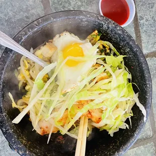 a bowl of food with chopsticks