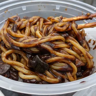 a bowl of noodles with chopsticks