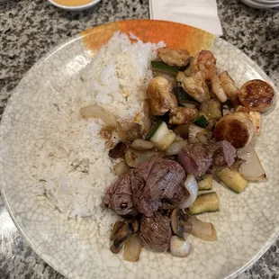 Dinner for two with steamed rice, shrimp, scallops, steak and lobster over stir fry vegetables.