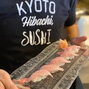 a man holding a plate of sushi