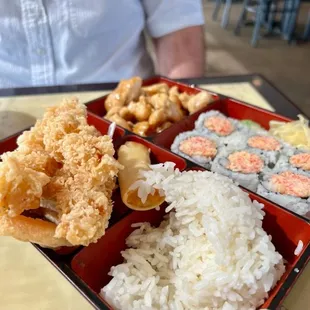 Bento box with tempura shrimp and chicken.
