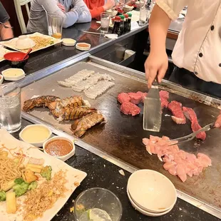 a man cutting meat on a grill