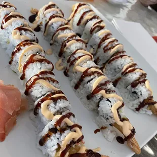 a plate of sushi rolls with sauce on them