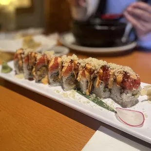 a plate of sushi with a person in the background