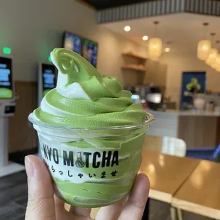 a hand holding a cup of matcha