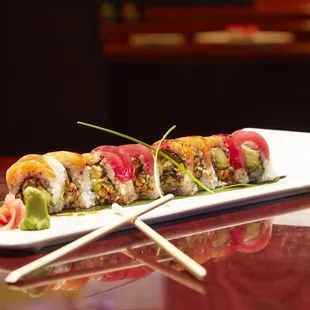 a plate of sushi with chopsticks