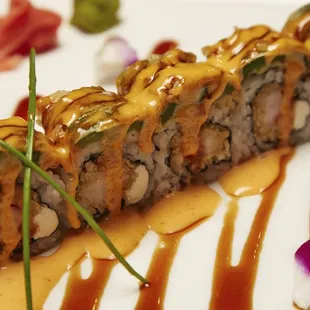 a sushi roll with sauce and garnish