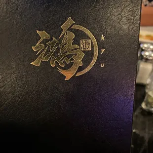 a close up of a black book with gold lettering