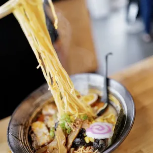 a bowl of ramen noodles with chopsticks