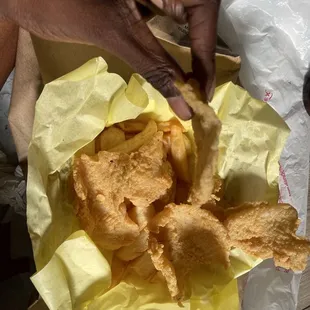 a hand grabbing a piece of bread